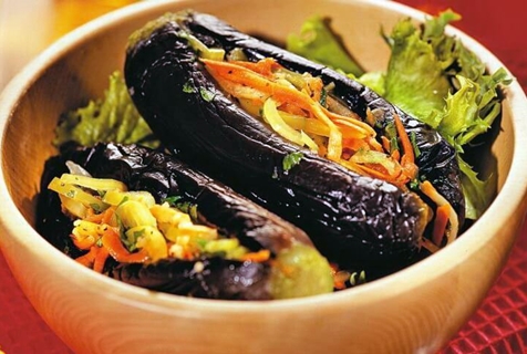 pickled eggplants with carrots, herbs and garlic in a bowl