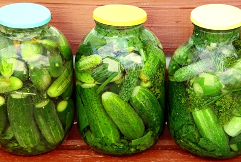 pickled cucumbers with celery in jars on the table