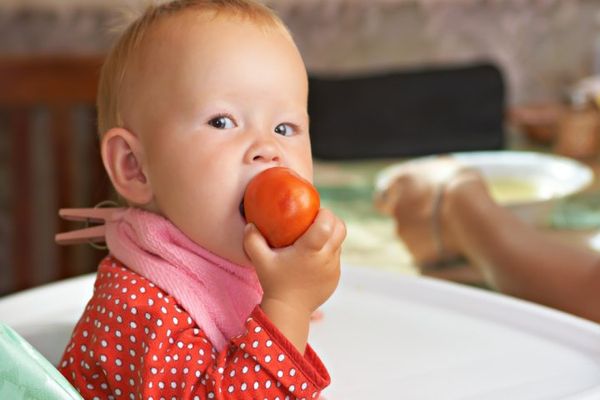 niño comiendo tomate