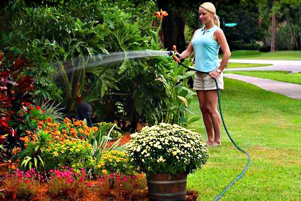 girl watering the garden with hoses